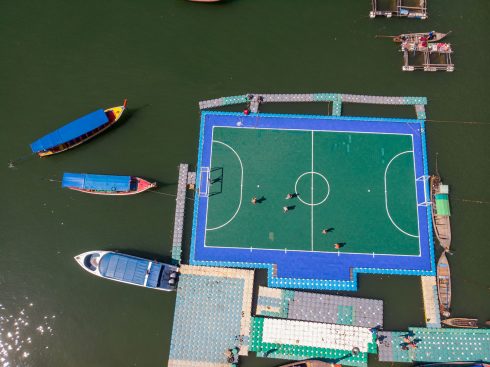 The floating football pitch with kids playing a match.